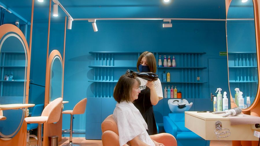 Hairdresser blow-drying a client's hair